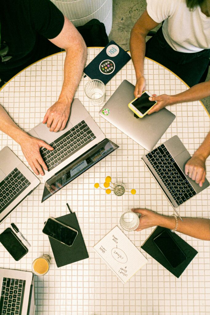 pexels-photo-3194519-3194519 Top view of a team collaborating with laptops, phones, and notes in a modern office.