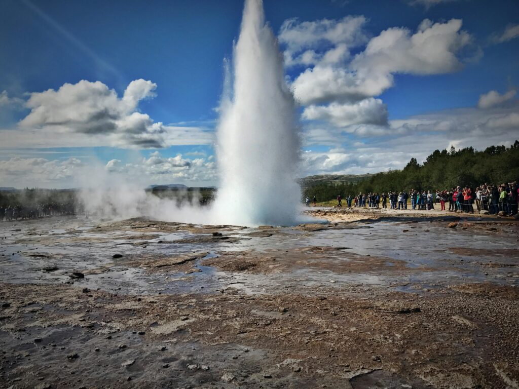 pexels-photo-5521715-5521715 Dramatic geyser eruption in Iceland with tourists watching nature's force up close.